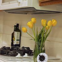 kitchen timer on counter next to jar of tulips