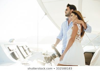 Attractive couple on a yacht enjoy bright sunny day on vacation