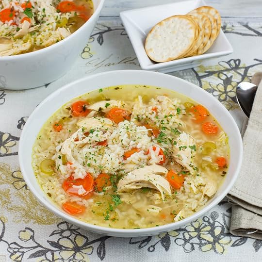 a bowl of Instant Pot Chicken and Rice Soup on a linen place mat with a bowl of crackers