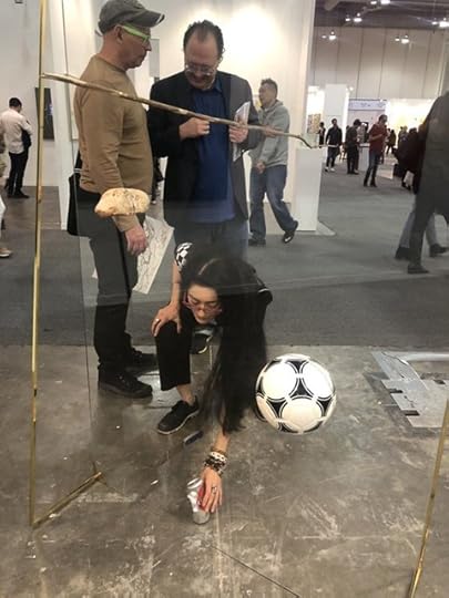 Avelina Lésper colocando la lata junto a la obra de Gabriel Rico