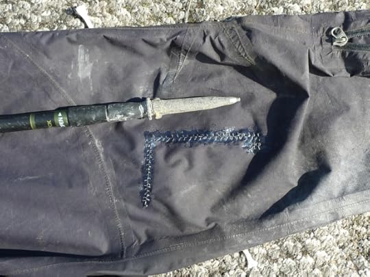 Rain pants torn by brush and repaired in the field with needle, thread, and Aquaseal