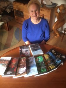 A middle aged woman with books on a table