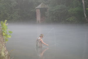 woman flyfishing fog