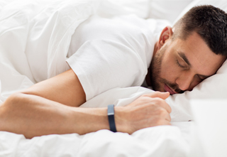 man sleeping with sleep tracker device