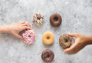 hands reaching for doughnuts