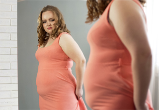 woman looking in mirror looking upset