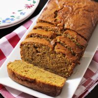 sliced loaf of pumpkin bread on tray with checked cloth