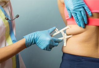 woman getting body fat measured with caliper