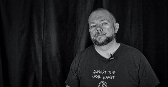 Per Axbom looking at camera. T-shirt caption says Support Your Local Planet