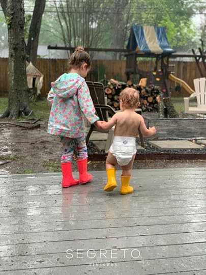 girl and baby walking in backyard