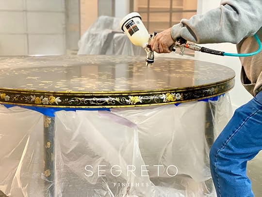embellishing top of custom painted black table with gold leaves