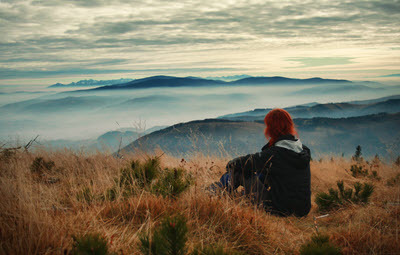 woman sitting in the mountains