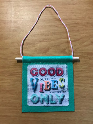 Good vibes only cross-stitch project mounted on green felt, stitched by Linzé Brandon