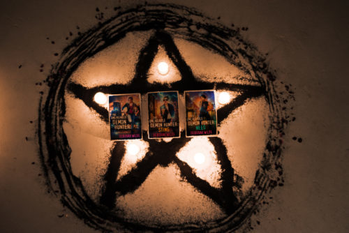 The covers of the first three books in the Nava Katz series by Deborah Wilde: The Unlikeable Demon Hunter, The Unlikeable Demon Hunter: Sting, The Unlikeable Demon Hunter: Need in a lit star inside a circle.