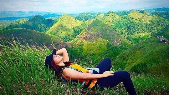 woman lying in the grass in the green hills