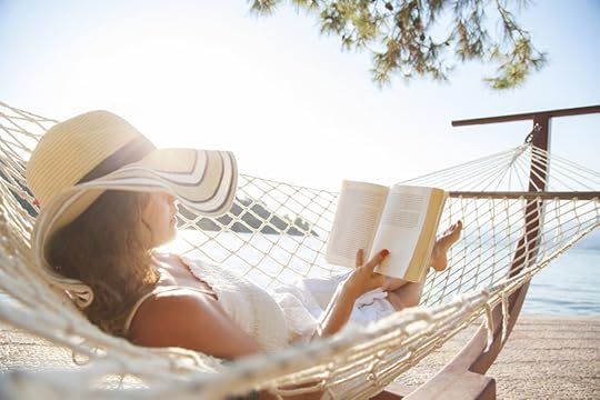 woman in hammock near the water reading a paperback