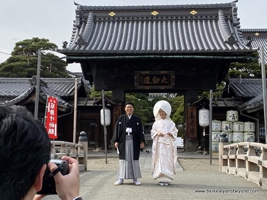 a bridal couple poses for pictures outside Zenkoji Temple in Nagano City, Japan