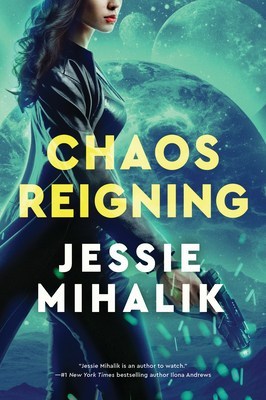 Side view of a pretty white woman with long dark hair wearing a long black leather jacket and holding a gun pointed down to the ground, against a background of swirling teal space stuff