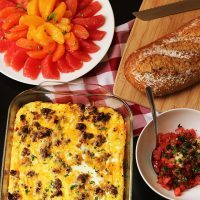 breakfast table with fruit egg cassserole bread and bruschetta