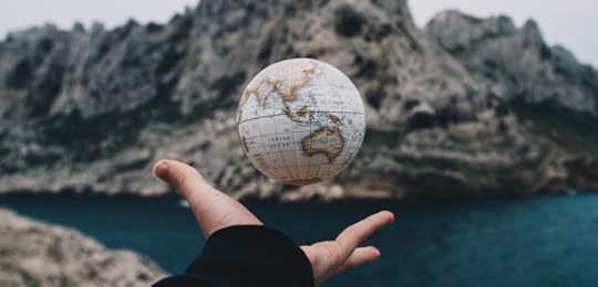 A small globe floating in the air above an open palm
