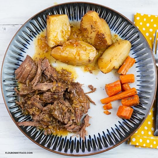 London Broil with vegetables and homemade gravy on a dinner plate.