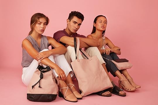 En la foto tres modelos muestran una mochila y dos carteras en tonos rosado y negro