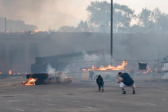 A man poses for a photograph in front of a burning busines… | Flickr