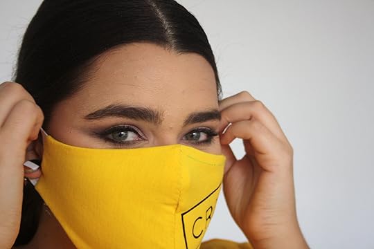 En la foto una mujer usa una Minkarillas de tela amarilla