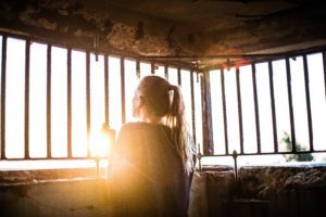 woman looking out bars