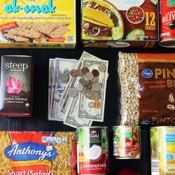 flatlay of groceries and cash on black tabletop