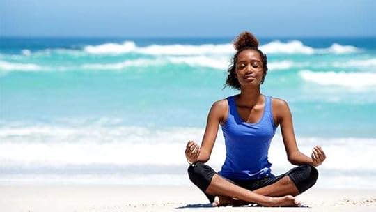 Young Black woman meditating on a beach