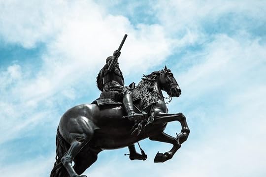 man riding horse statue under blue sky during daytime