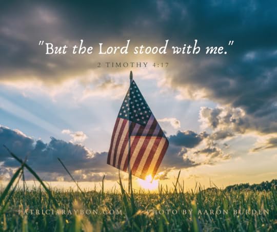 American flag in field with scripture 