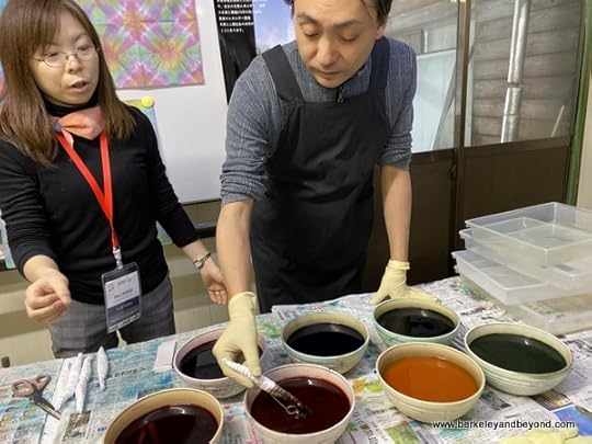 instructor demonstrates dipping tie-died cloth at Geocolor: Hachimantai Geothermal Dyeing in Hachimantai city, Japan