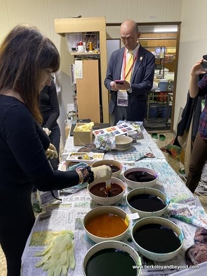 student dips tie-died cloth at Geocolor: Hachimantai Geothermal Dyeing in Hachimantai city, Japan