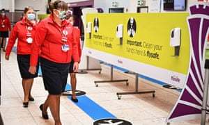 Airport staff at the main terminal at Edinburgh airport: Scotland has not relaxed its quarantine rules.