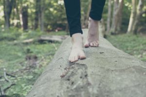 womans' barefeet walking on log