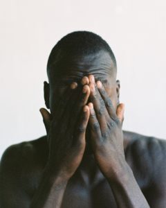 What do you think is the number one reason fear holds us back? Man holding his face wondering.