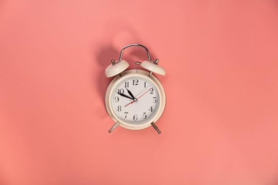 White alarm clock on pink background - flat lay