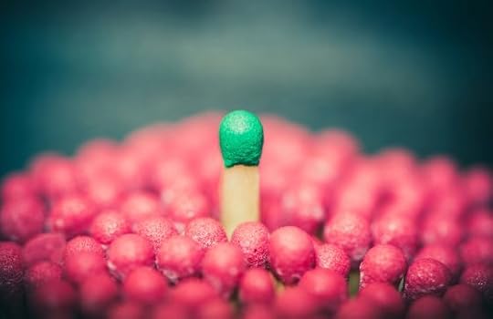 Image: wooden match with green top standing out from a field of wooden matches with red tops