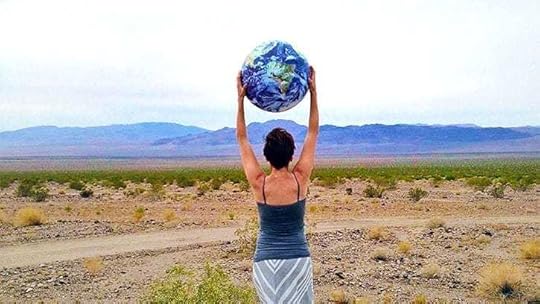 woman holding a globe over her head in the desert