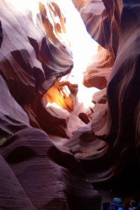 Twisted, multi-colored rock on both sides leads up to a thin slice of sky