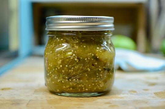 Jar of finished roasted salsa verde on a kitchen countertop.