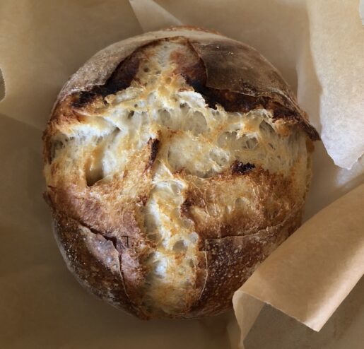 Photo of a loaf of homemade sourdough bread in a Dutch ove