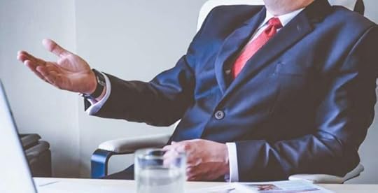Professional in a suit sitting at desk and talking
