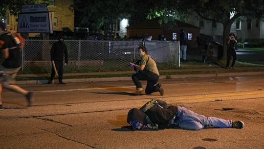 Photo of Kyle Rittenhouse in the street with a rifle
