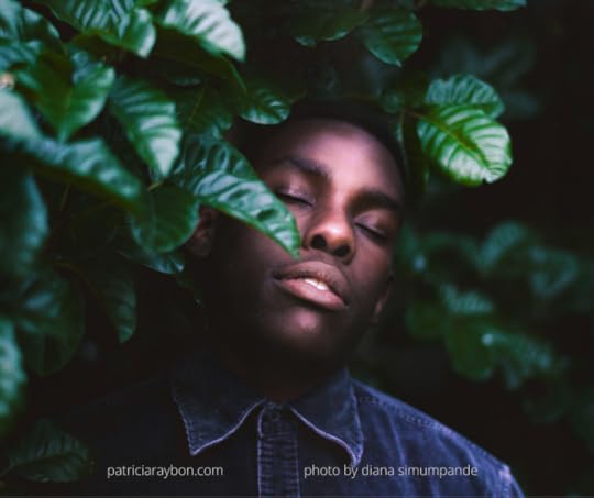 photo of young black man resting amid green trees in a serene setting