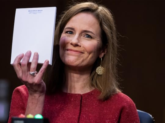 Amy Coney Barrett holds up an empty notepad and flashes a shit-eating smirk. (TOM WILLIAMS / CQ-ROLL CALL, INC VIA GETTY IMAGES)