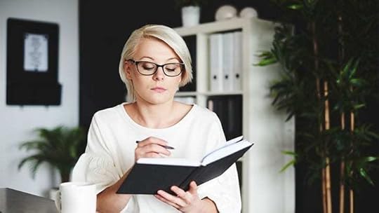 woman writing in a black notebook