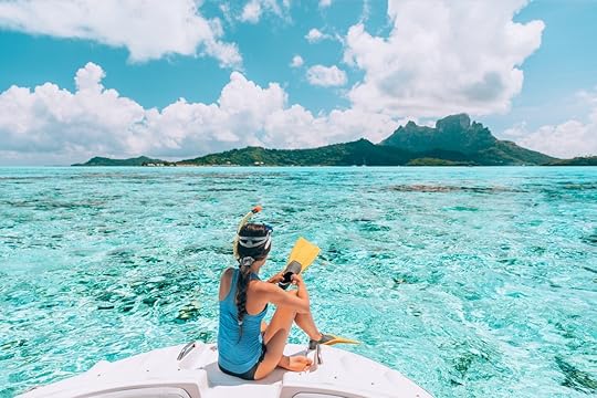 Female traveler ready to snorkel in the clear waters of Bora Bora island with coral reefs